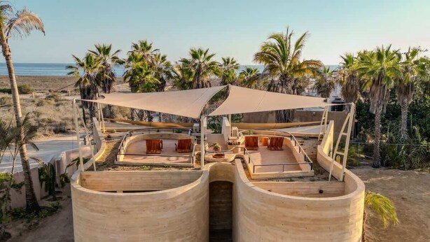 A beachside structure with a curved roof and a central passageway.