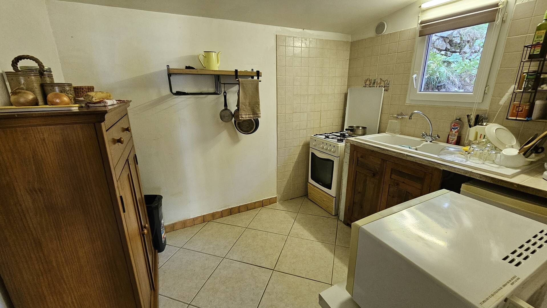 Une cuisine équipée d’une cuisinière, d’un four, d’un évier et de meubles de rangement en bois.