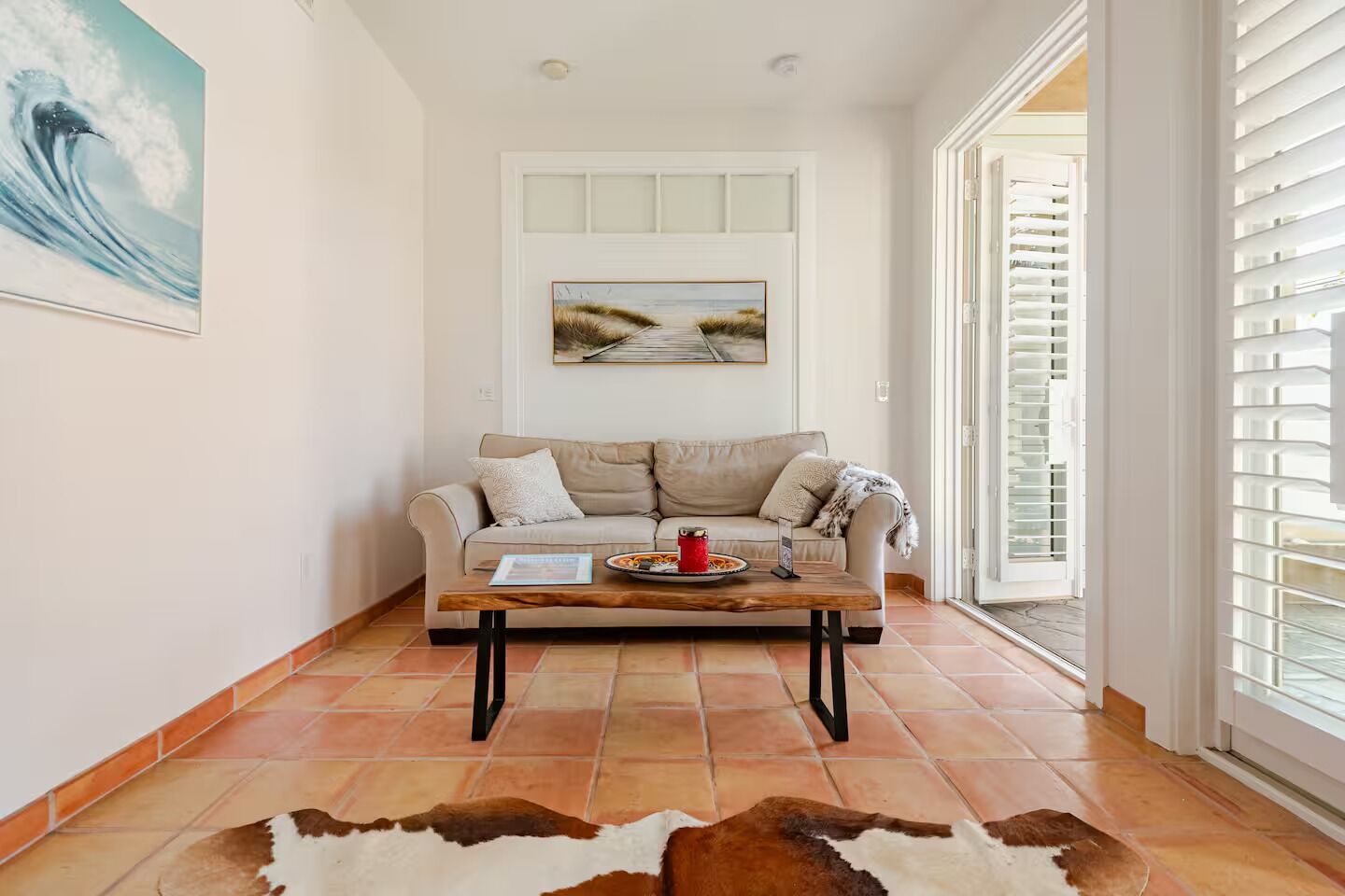 A living room with a sofa, a coffee table, and a rug.
