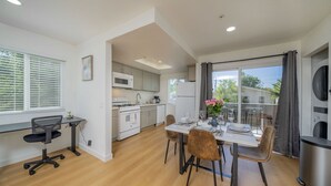 A modern kitchen with white appliances, a dining area with a table set for two, and a large window with blinds. - 2BD/2BA Apartment near DT Alhambra (Alhambra)