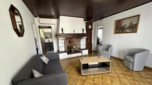 A living room with a sofa, armchairs, a coffee table, a fireplace, and a painting on the wall. - Gîte Jean de Nasse - CASTETS (CASTETS)