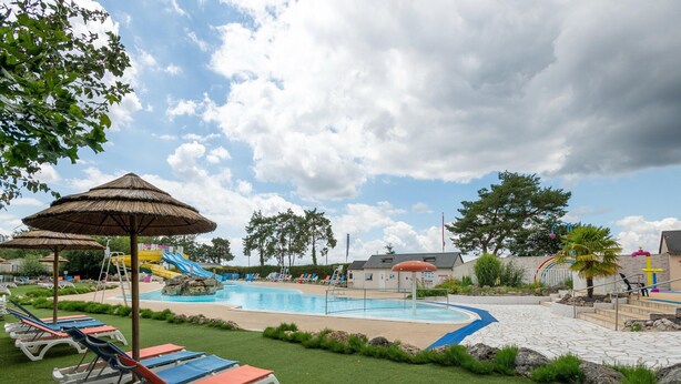 A swimming pool area with lounge chairs, a slide, and a small building. - Mobile Home in Veuzain-sur-loire With Garden (Veuzain-sur-Loire)