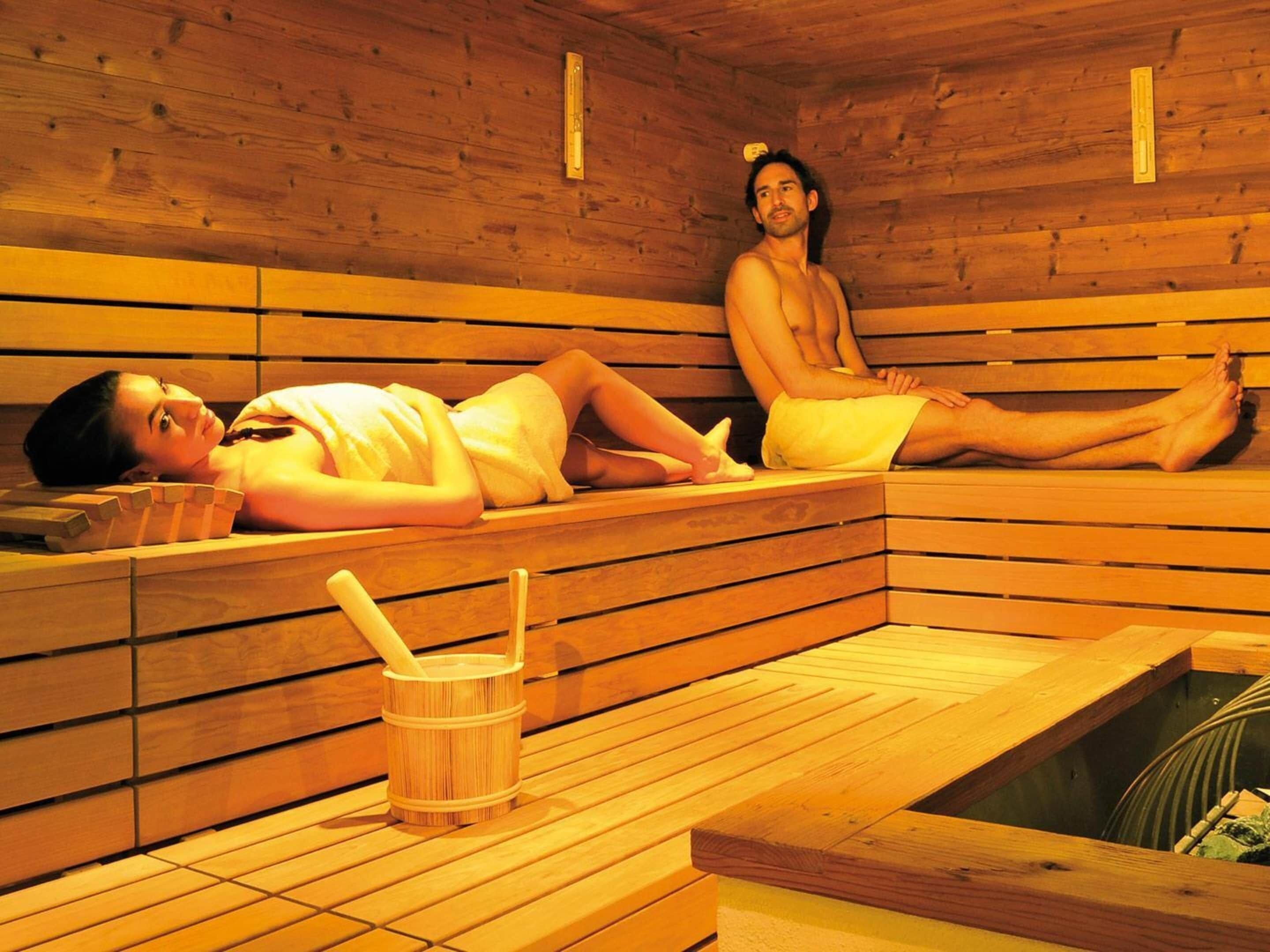 Eine Sauna mit Holzbänken und einem Holzfass.
