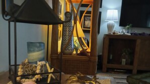 Ein gemütliches Wohnzimmer mit einer dekorativen Lampe, einem Bücherregal und einem Fernseher.