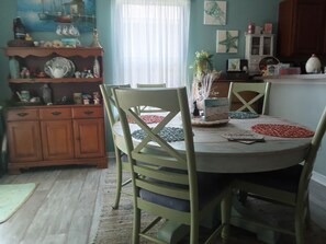 A dining area with a round table, chairs, and a decorative centerpiece.