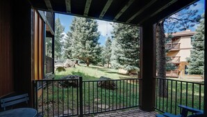 A covered outdoor area with a patio, a table, and benches. - Recently-renovated condo across from the Fox shuttle stop! (Angel Fire)