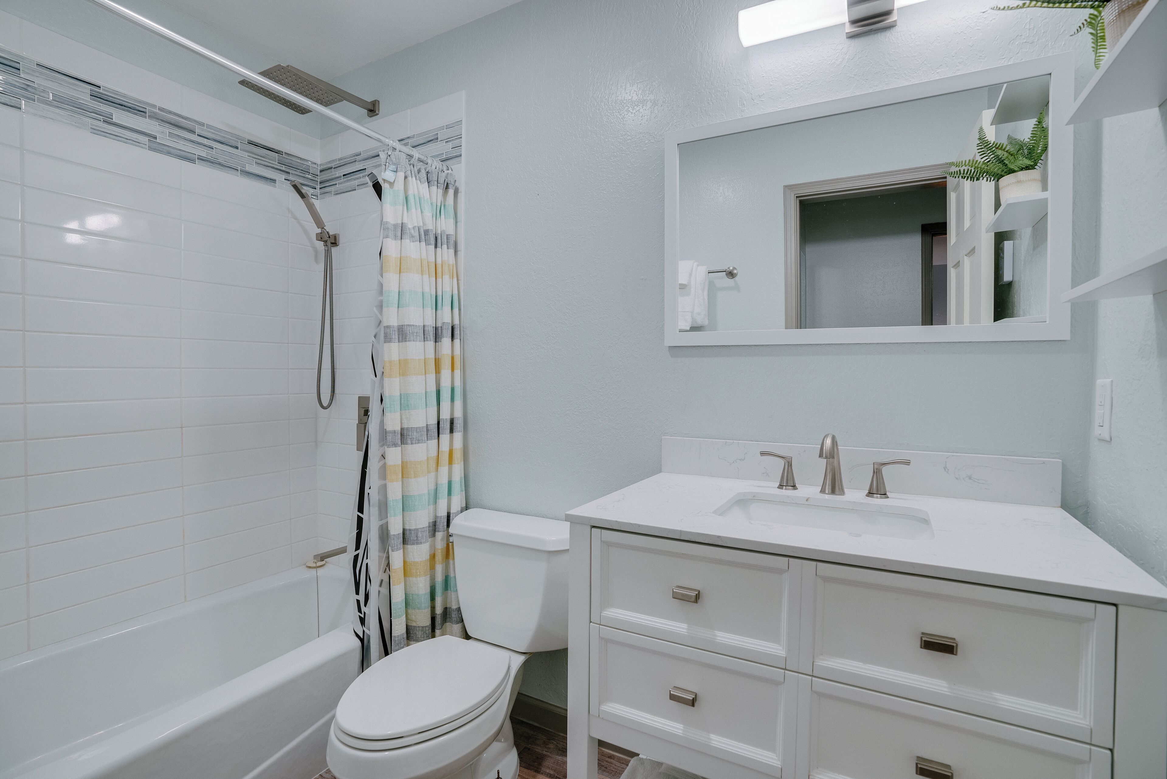 Une salle de bain avec une baignoire, des toilettes et un meuble-lavabo avec des tiroirs.