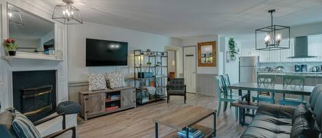 TV connectée, cheminée, livres, écrans d'ordinateur