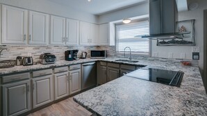 A modern kitchen with white cabinets, granite countertops, and stainless steel appliances. - Recently-renovated condo across from the Fox shuttle stop! (Angel Fire)