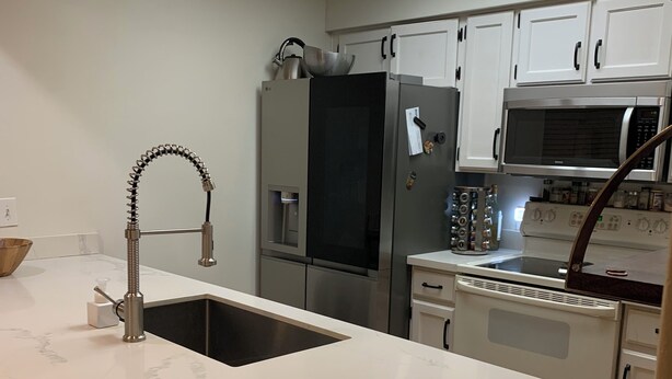 A modern kitchen with a marble countertop, stainless steel appliances, and white cabinetry. - Modern, Peaceful Tempe Condo • Pool & Fast Wi-Fi (Tempe)