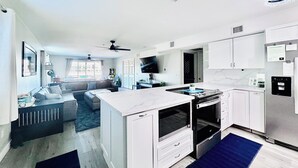 A modern kitchen with white cabinets, a built-in oven, and a stainless steel refrigerator. - NEWLY REMODELED! 2bd, 2bath @Kingsview w.Beachfront View of the Channel (Lake Havasu City)
