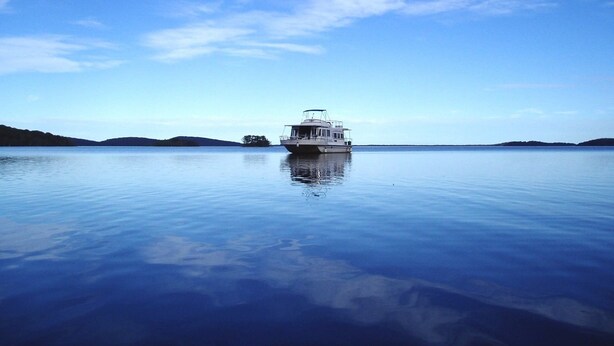 A boat on calm water with a clear sky. - Houseboat Hire Myall Lakes National Park NSW (Bulahdelah)