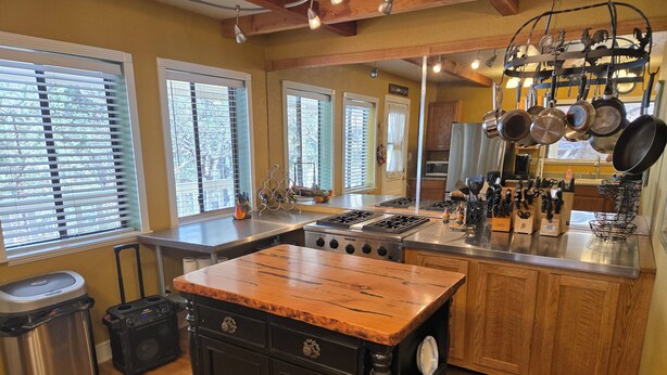 Una cocina con isla central, armarios de madera y estufa de acero inoxidable.