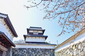 A traditional Japanese building with a multi-tiered roof and stone walls. - Axion Hotels Tenjin (Fukuoka)
