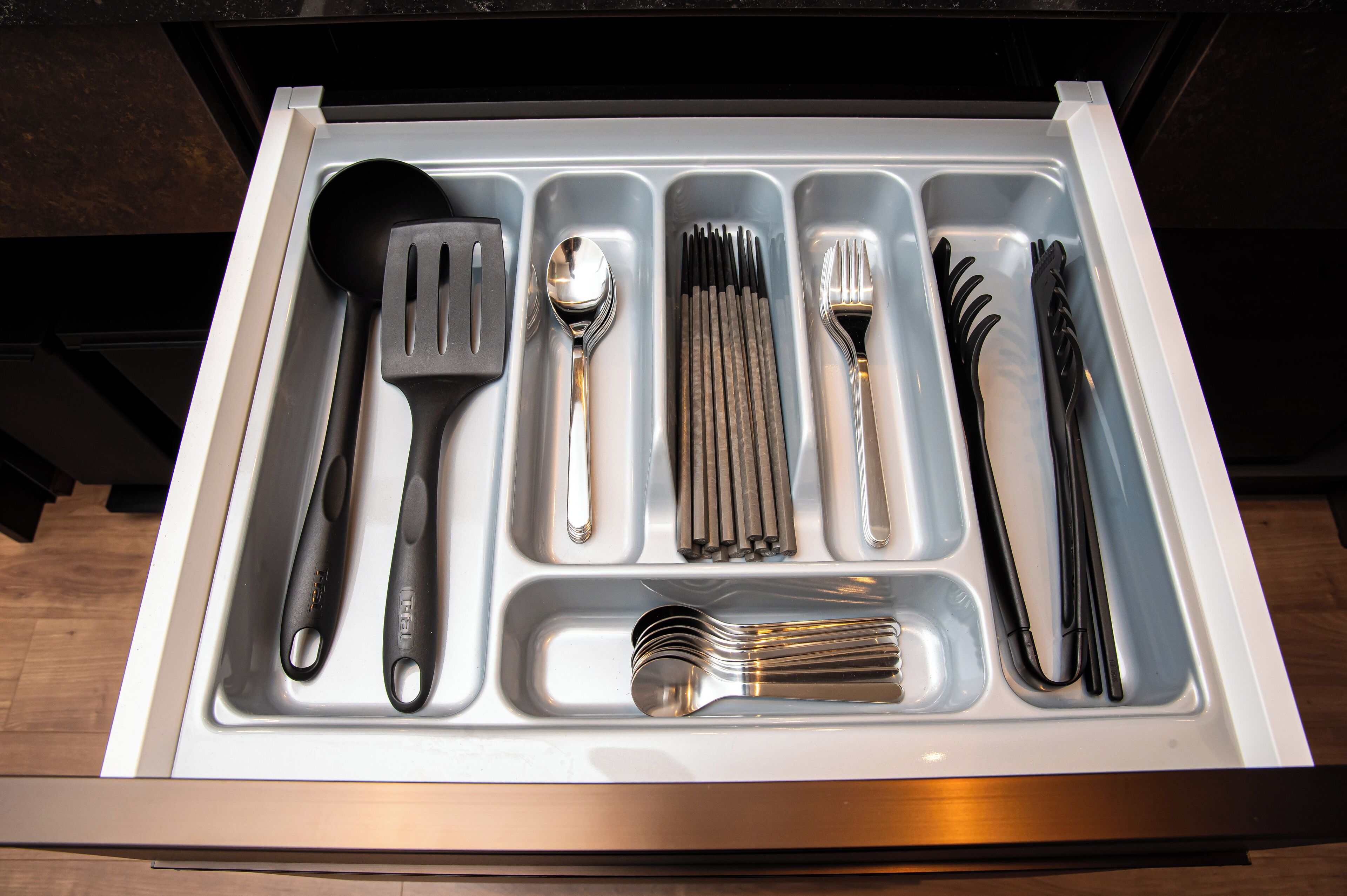 A drawer with various kitchen utensils neatly organized.