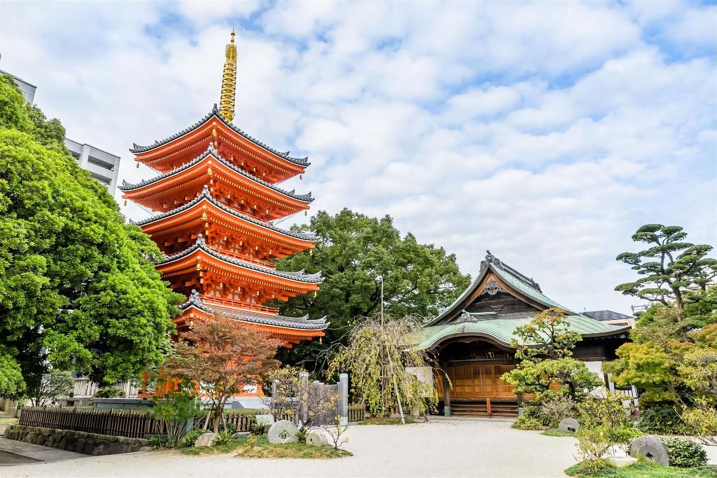 A traditional Japanese pagoda with multiple tiers, surrounded by lush greenery and a well-maintained garden.
