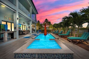 A pool area with lounge chairs and a bar. - New Oceanfront 5BR + Bonus Room 6BA  •Pool & Hot Tub• Dock•Near Sombrero Beach (Marathon)