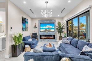 TV connectée, cheminée, livres, chaîne hi-fi