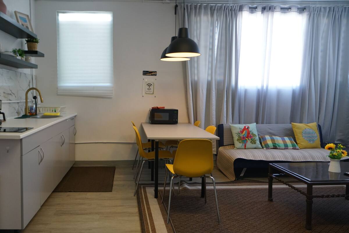 A compact living space with a kitchenette, dining area, and seating area.