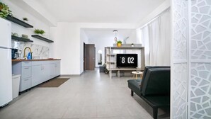 A modern kitchen with white cabinets, a marble backsplash, and a black clock displaying 8:02. - CARIBBEAN STARS (Carolina)