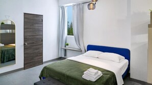 A bedroom with a bed, a mirror, a window with curtains, and a bedside table. - CARIBBEAN STARS (Carolina)