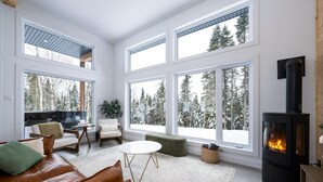 A spacious living room with large windows, a fireplace, and a cozy seating area.