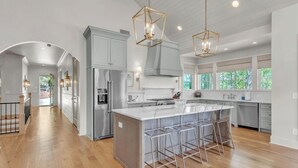 A spacious kitchen with a large island, stainless steel appliances, and pendant lighting. - Experience Ultimate Relaxation: Stunning Lakeside Retreat (Dadeville)