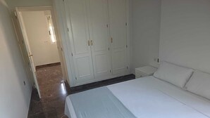 A bedroom with a bed, a wardrobe, and a nightstand. - Birch house (San Vicente del Raspeig)