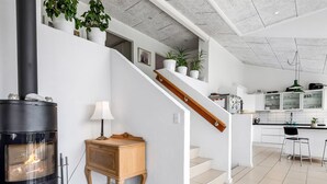 A modern kitchen with white cabinets, a black stove, and a wooden sideboard. - "Jonce" - 800m from the sea by Interhome (Ebeltoft)