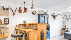 A modern kitchen with a wooden bar, bar stools, and various kitchen appliances. - "Jonce" - 800m from the sea by Interhome (Ebeltoft)