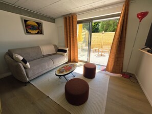 Een woonkamer met een bank, een poef en een salontafel.