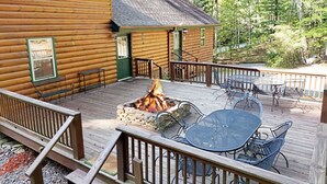 A wooden cabin with a deck, a fire pit, and outdoor furniture. - S`more Waggin` Cabin: Pet-Friendly--wifi, firepit, pool table (Blue Ridge)