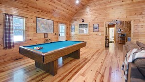 A wooden cabin interior with a pool table, a couch, and a map on the wall. - S`more Waggin` Cabin: Pet-Friendly--wifi, firepit, pool table (Blue Ridge)