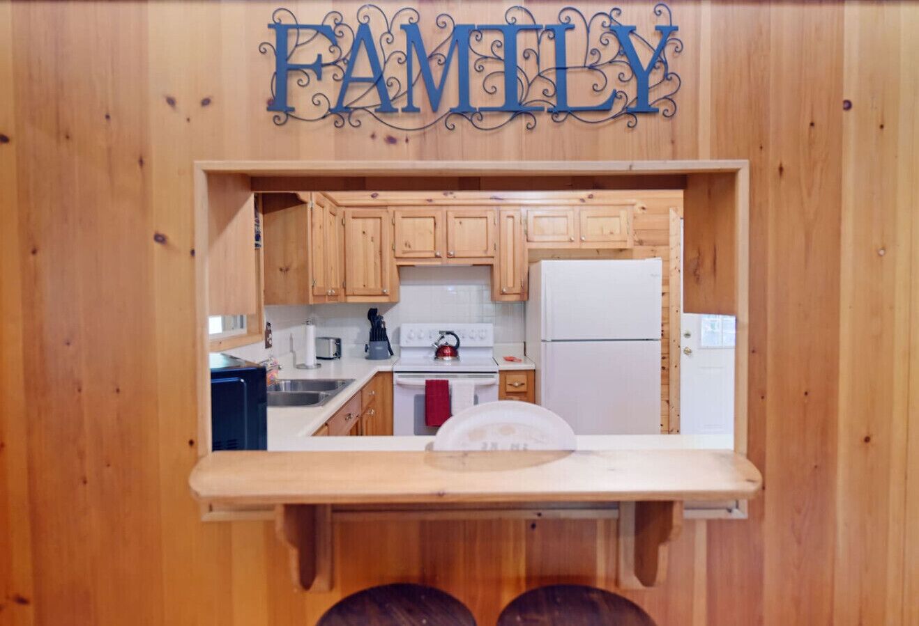 A kitchen with wooden cabinets, a white stove, and a refrigerator.