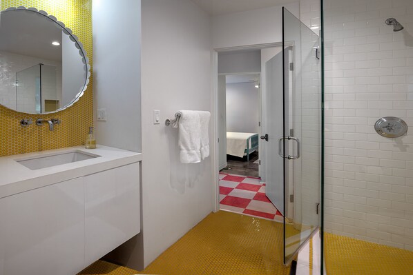A bathroom with a white sink, a large mirror, and a glass shower enclosure.