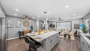 Una cocina moderna con una isla grande, piso de madera y decoración contemporánea.