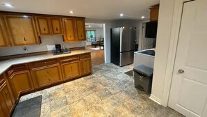 A modern kitchen with wooden cabinets, a granite countertop, a stainless steel refrigerator, and a built-in oven. - Cottage Paradise - Water, Woods and Nature (Flesherton)