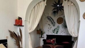 A room with a bed, a sofa, and a decorative archway.