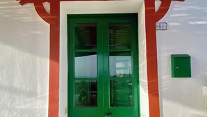 A green door with a red archway, a number '81' sign, and a green mailbox.