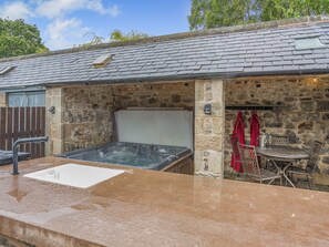 A stone building with a hot tub, outdoor seating, and a stone wall. - The Old Cottage - UK49169 (Beadnell)