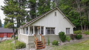 A single-story wooden cabin with a porch and a small staircase leading to the entrance. - Wilderness West Resort Cabin 1 (Colville)