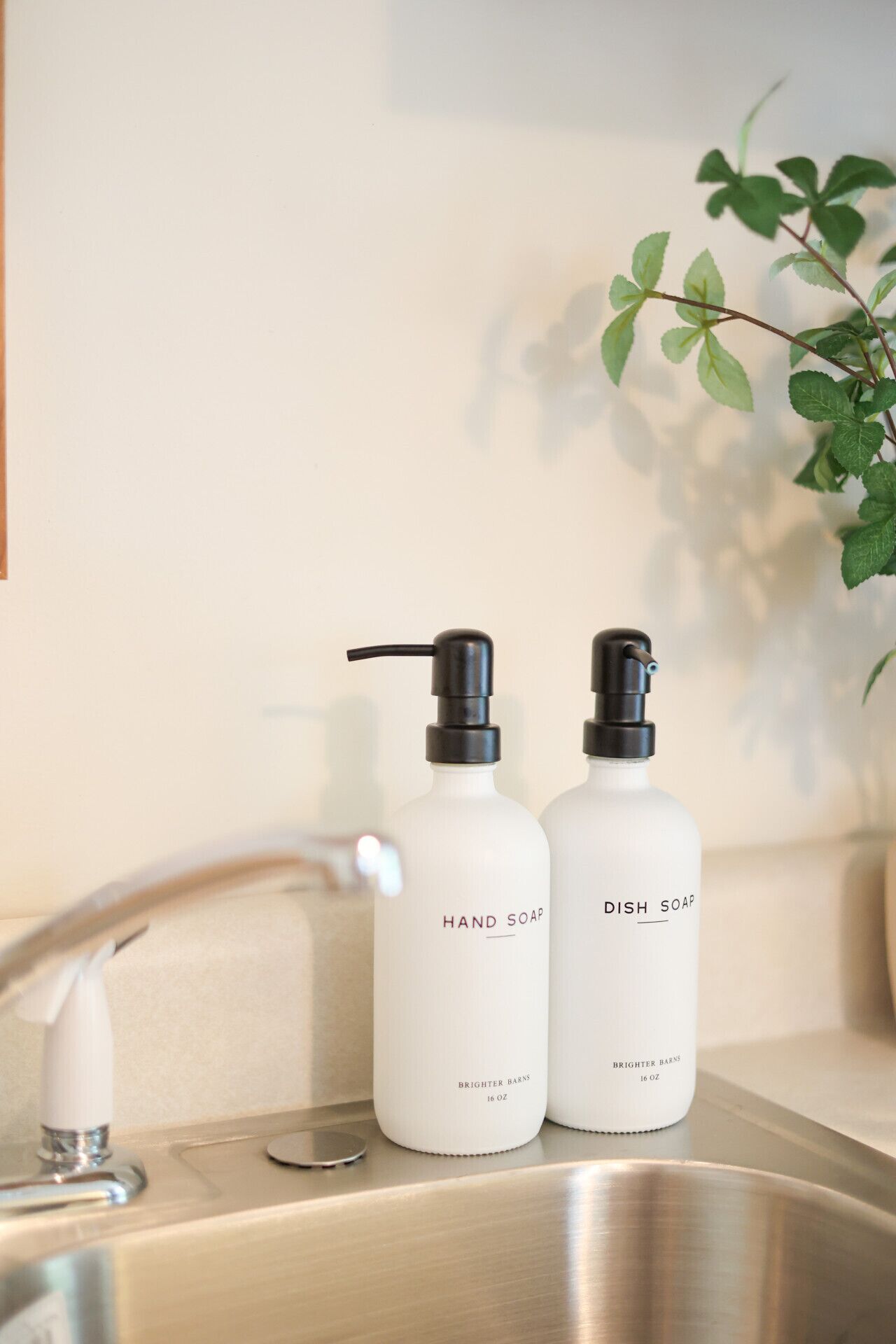 Dos botellas de jabón para manos y platos sobre un lavamanos de baño.