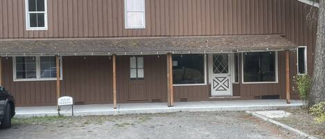 Un bâtiment à deux étages doté d’un porche couvert et d’un panneau indiquant les places de stationnement réservées aux visiteurs.