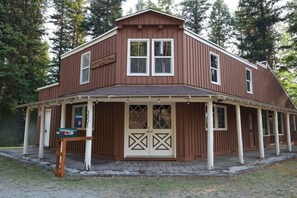 Ein zweistöckiges Holzhaus mit Veranda, Briefkasten und Schild, das es als Wildnis-Resort kennzeichnet.
