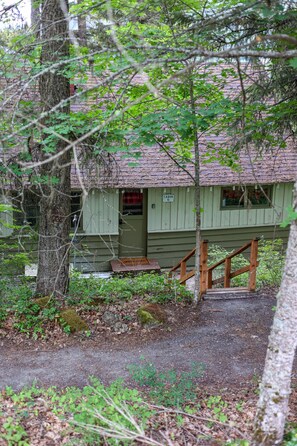 A cabin with a wooden staircase leading to a door marked "Cabin 6". - Wilderness West Resort Cabin 6 (Colville)