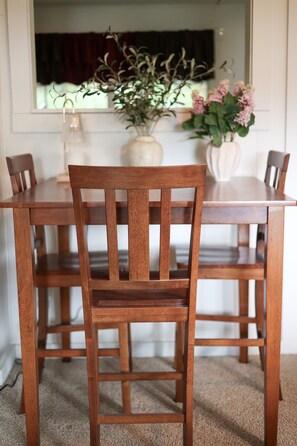 A dining table with four wooden chairs. - Wilderness West Resort Cabin 6 (Colville)