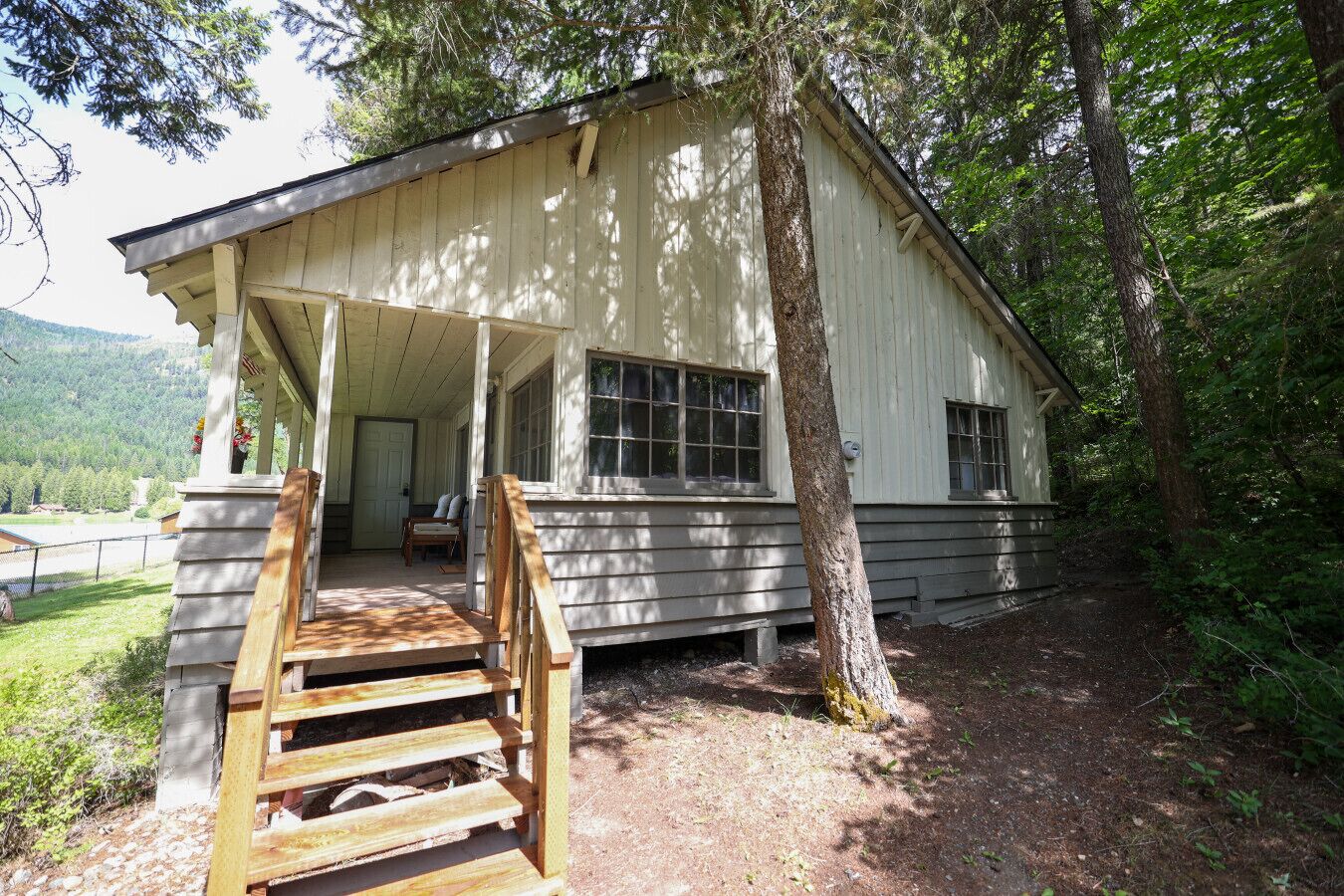 A wooden cabin with a porch and a staircase leading to the entrance.