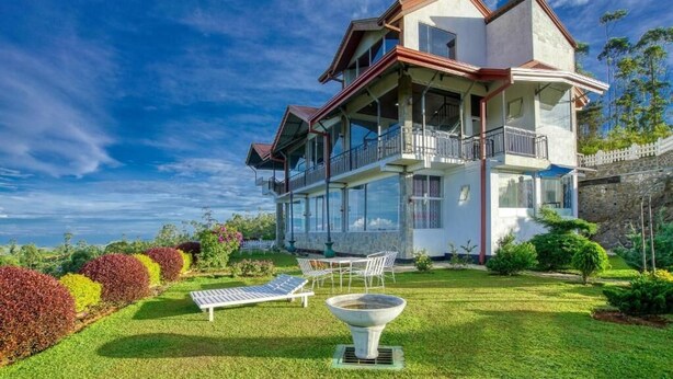 A two-story house with a balcony, a lawn, and a garden. - Daynish Rock Bungalow (Hatton)