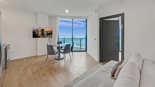A modern apartment with a balcony, a dining area, and a living room. - Spacious Miami 3BR w/ City & Bay Views (Miami)