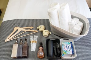 A neatly arranged set of toiletries and a bowl of towels on a bed. - b&Kuromon2 (Osaka)